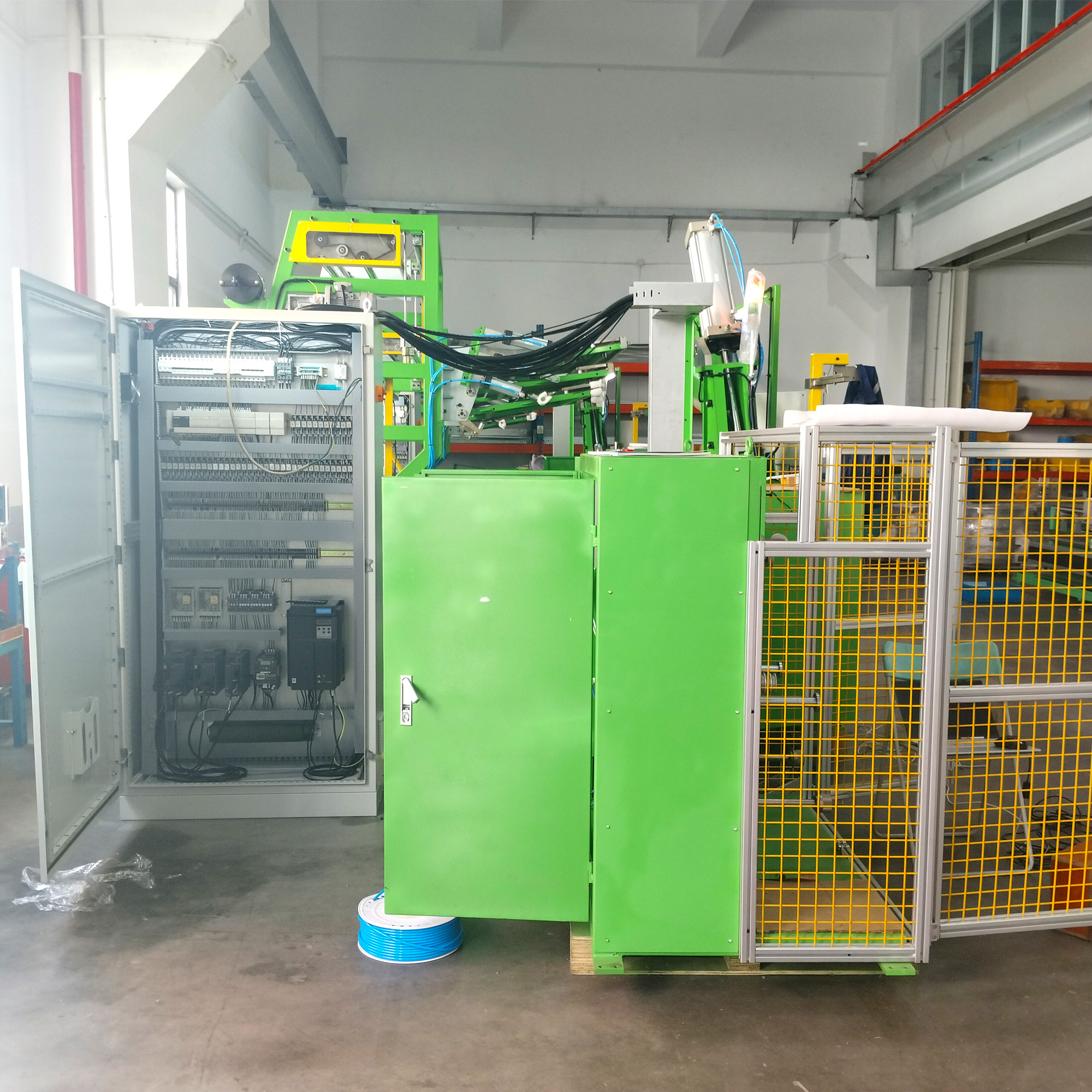 Forming machine beside an open electrical control cabinet